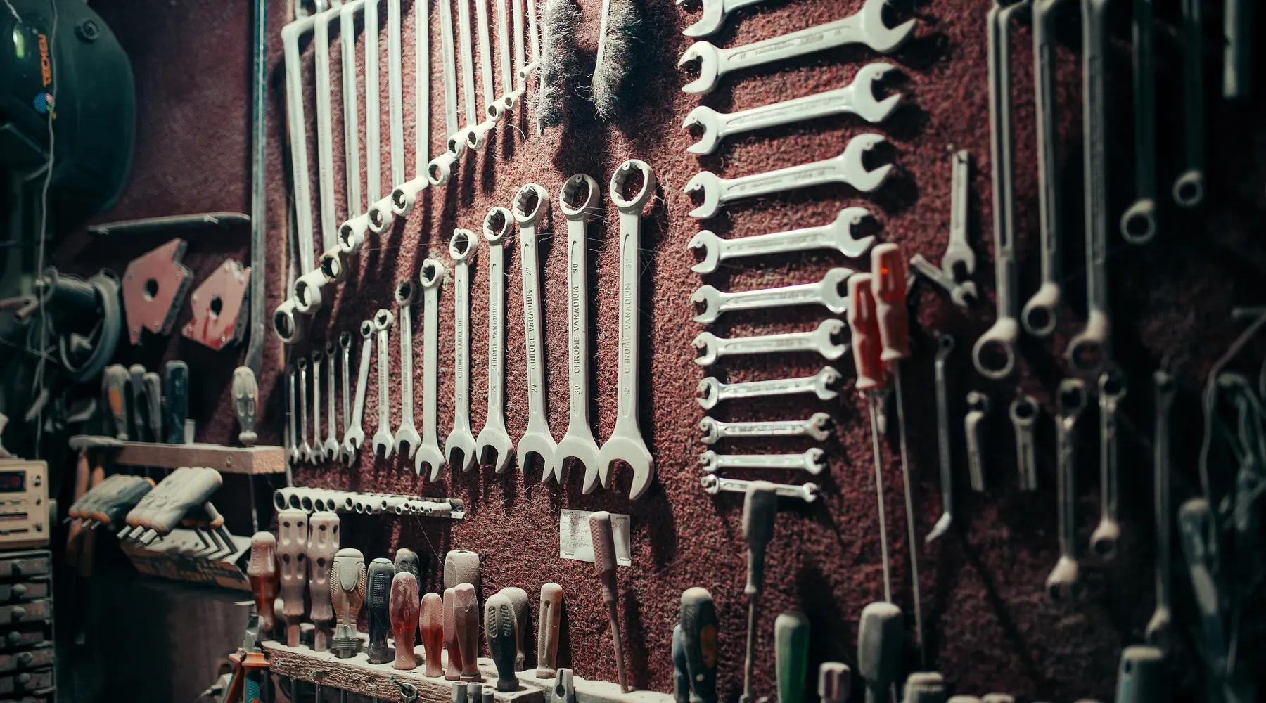 Rows of wrenches and hand tools hung on a workshop wall