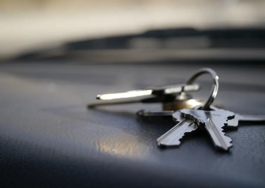 A bunch of keys lying on the dashboard of a car